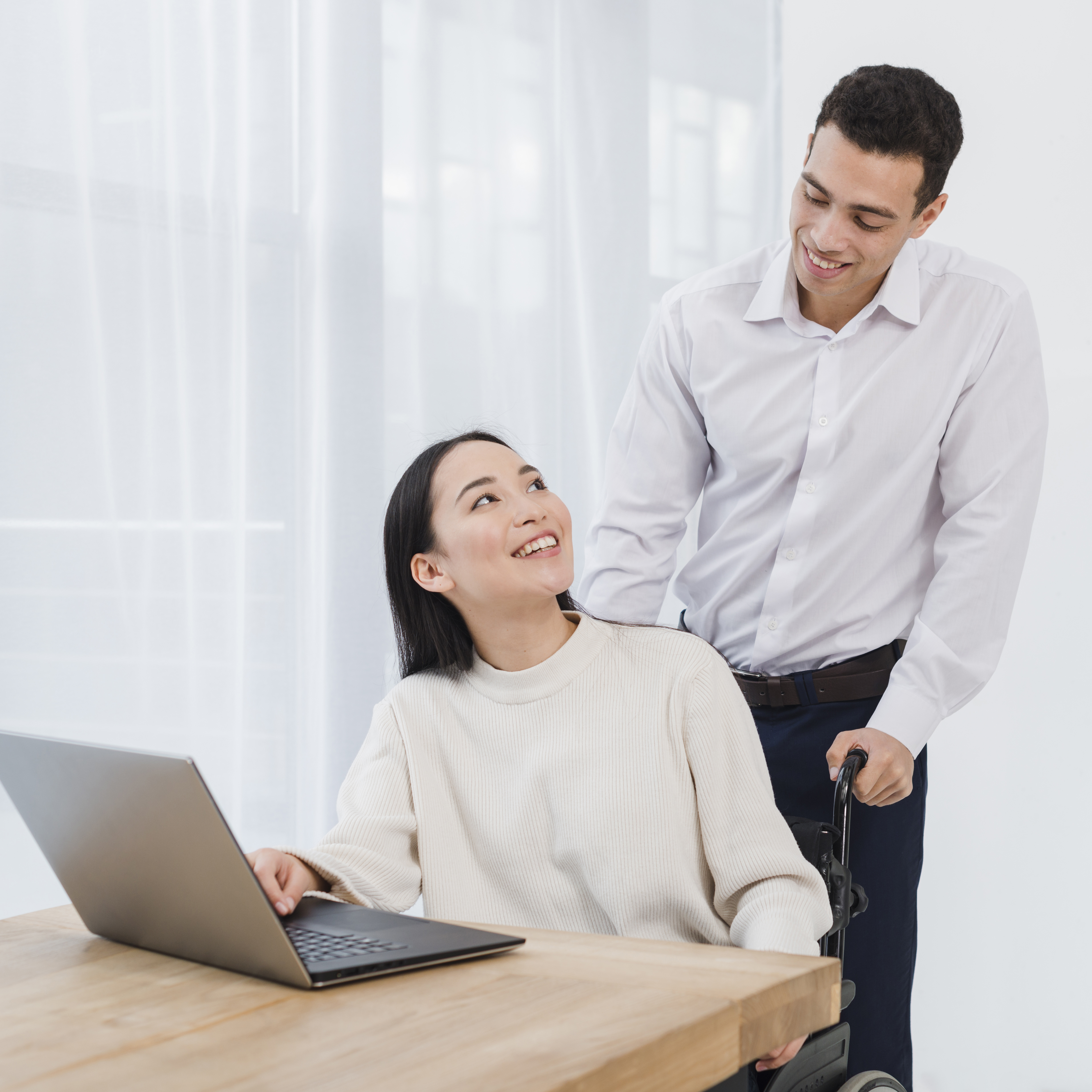 happy-young-man-standing-asian-woman-using-laptop-wooden-table