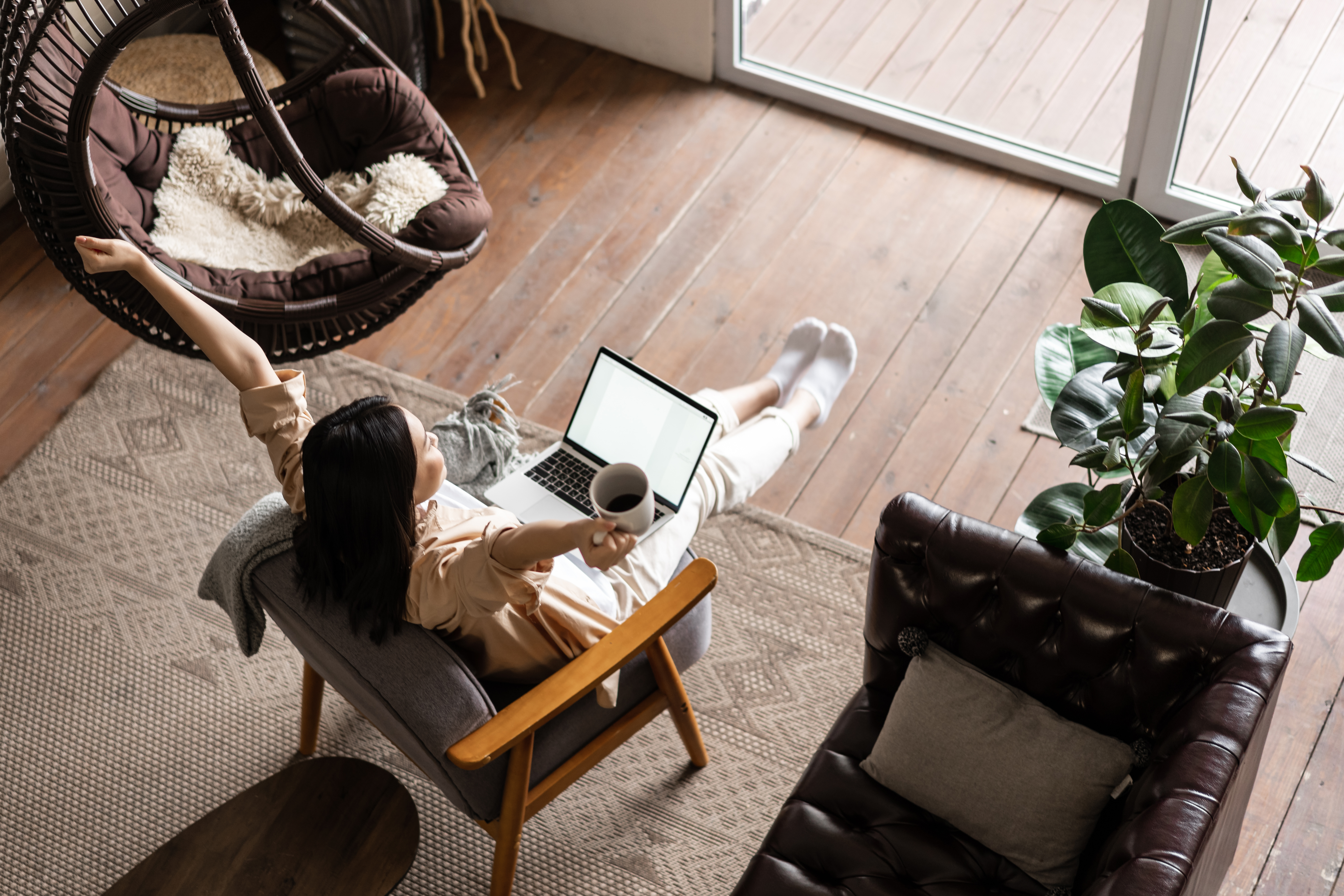 A woman raising her hands while having remote work